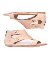 Pair of beige open-toe Bed Stu Soto leather sandals with a cushioned footbed, side cutout design, brass button accents, flat soles, and back zippers, shown in profile against a white background.