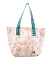 The Stevie tote by Bed Stu features light beige leather with a marbled brown pattern, teal handles, visible edge stitching, and a small rectangular logo patch on the lower front—perfect for everyday use.