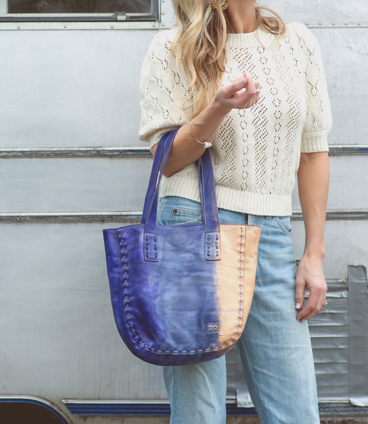 A woman holding a Bed Stu Stevie tote bag in blue and tan.