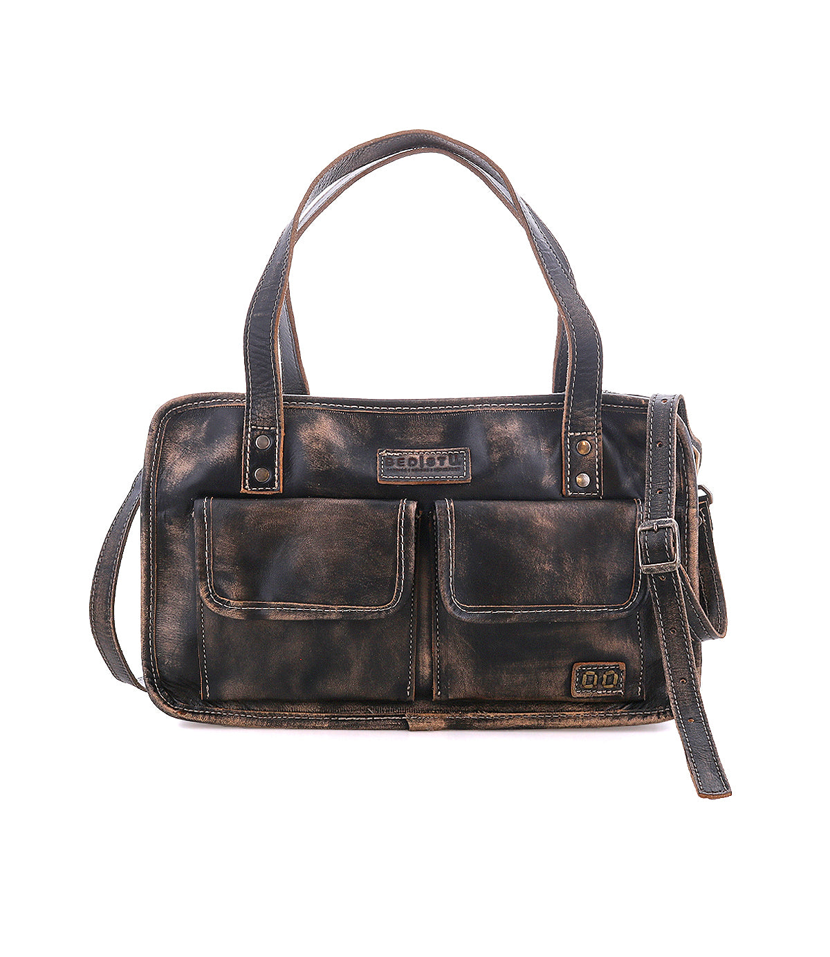 The Bed|Stü Stuffy is a brown leather handbag featuring a spacious interior, two front flap pockets, dual handles, and an adjustable shoulder strap, shown against a white background.