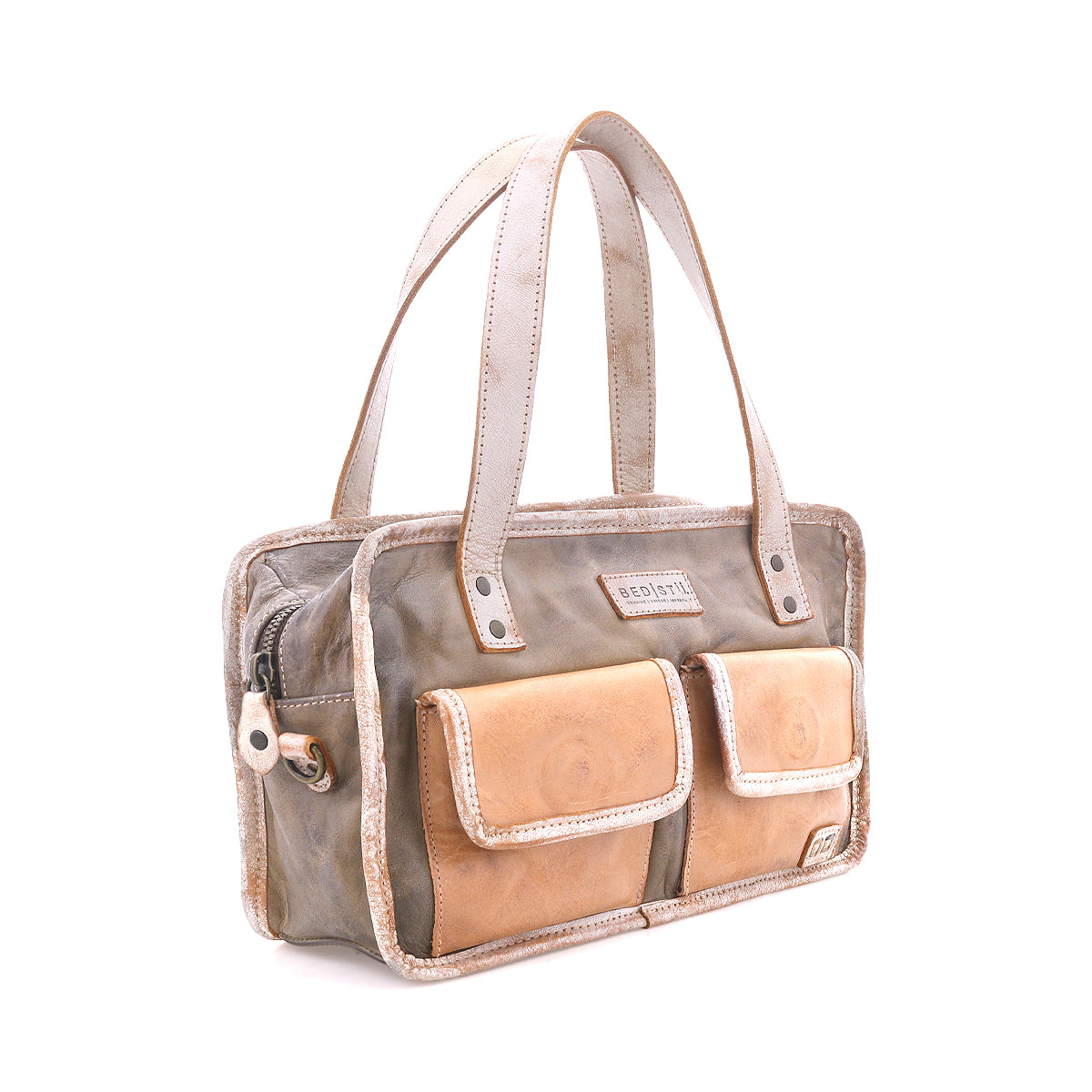 The Bed|Stü "Stuffy" bag is a rectangular, preppy style featuring two tan front pockets, beige handles, and a zipper closure, with a structured silhouette and shown on a white background.
