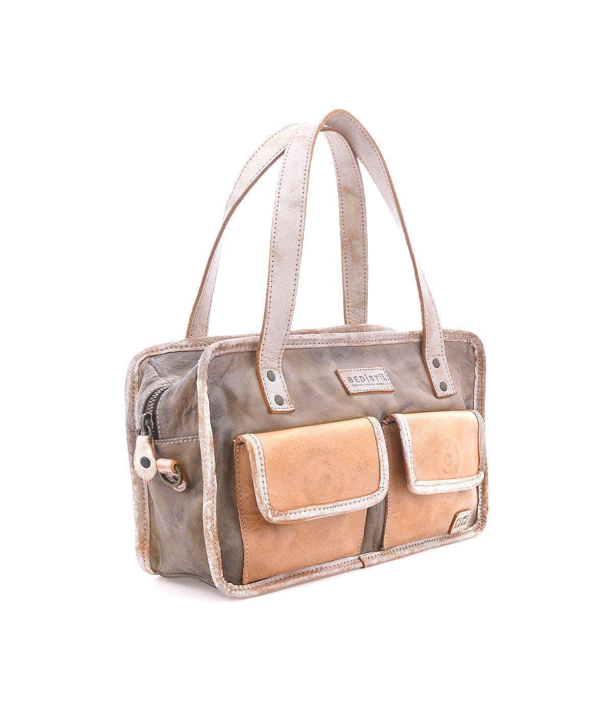 The Bed|Stü "Stuffy" bag is a rectangular, preppy style featuring two tan front pockets, beige handles, and a zipper closure, with a structured silhouette and shown on a white background.
