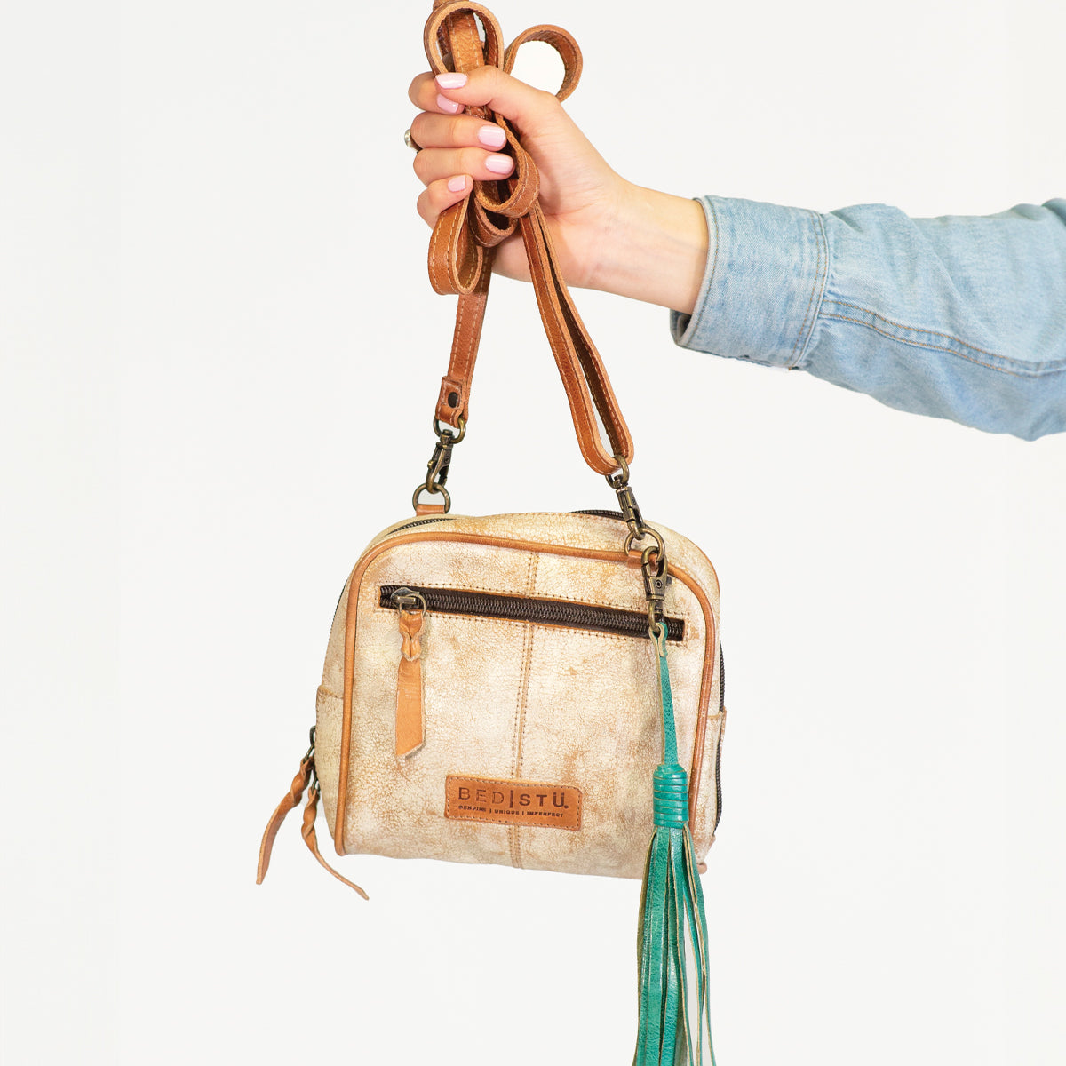 A person showcasing their personal expression through an accessory - a bag adorned with a stylish Bed Stu Tassel Clip.