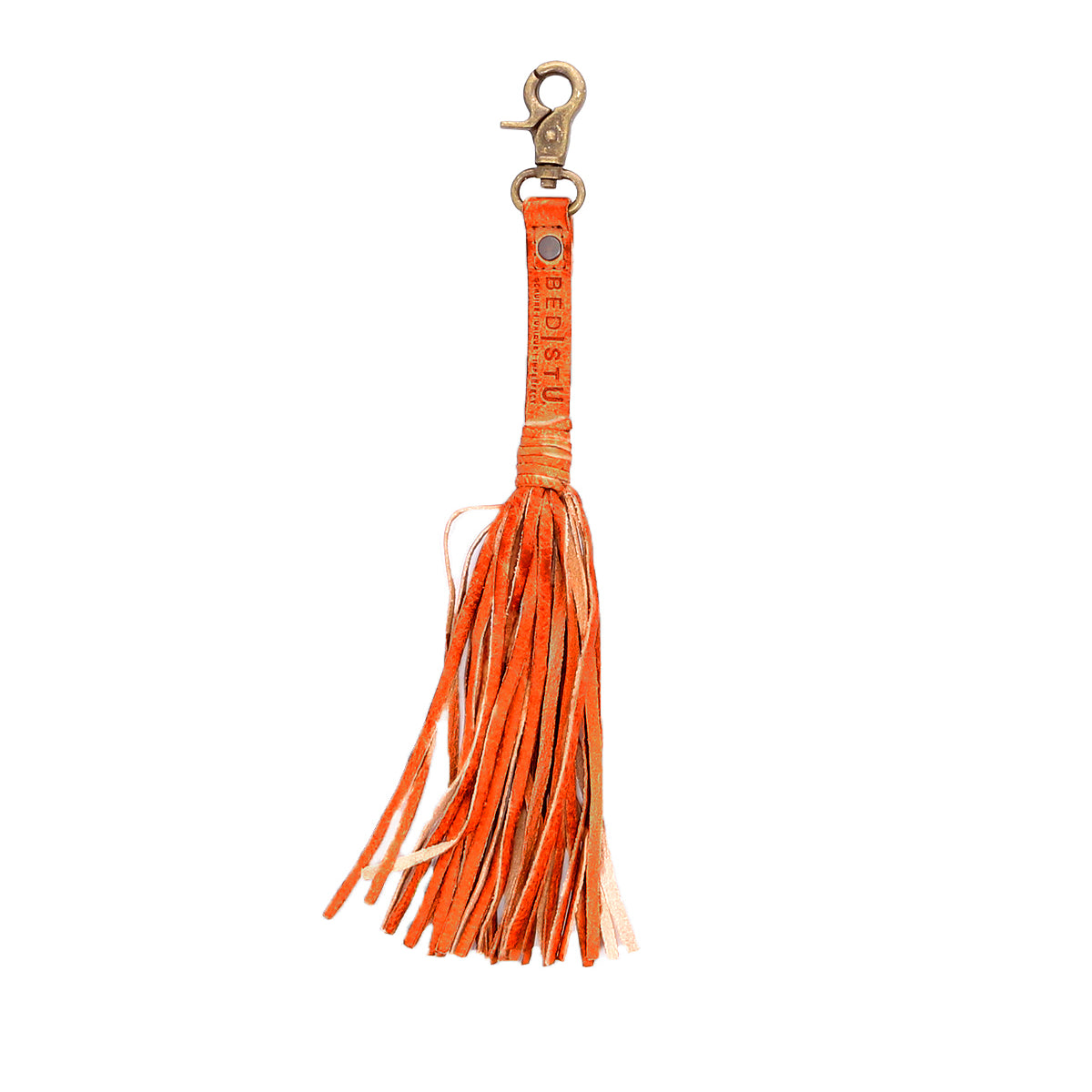 The Bed Stu Tassel Clip is an orange leather keychain with a metal clasp, made from premium leather. It includes long, thin strips and stamped text on the handle, adding versatility to any ensemble.
