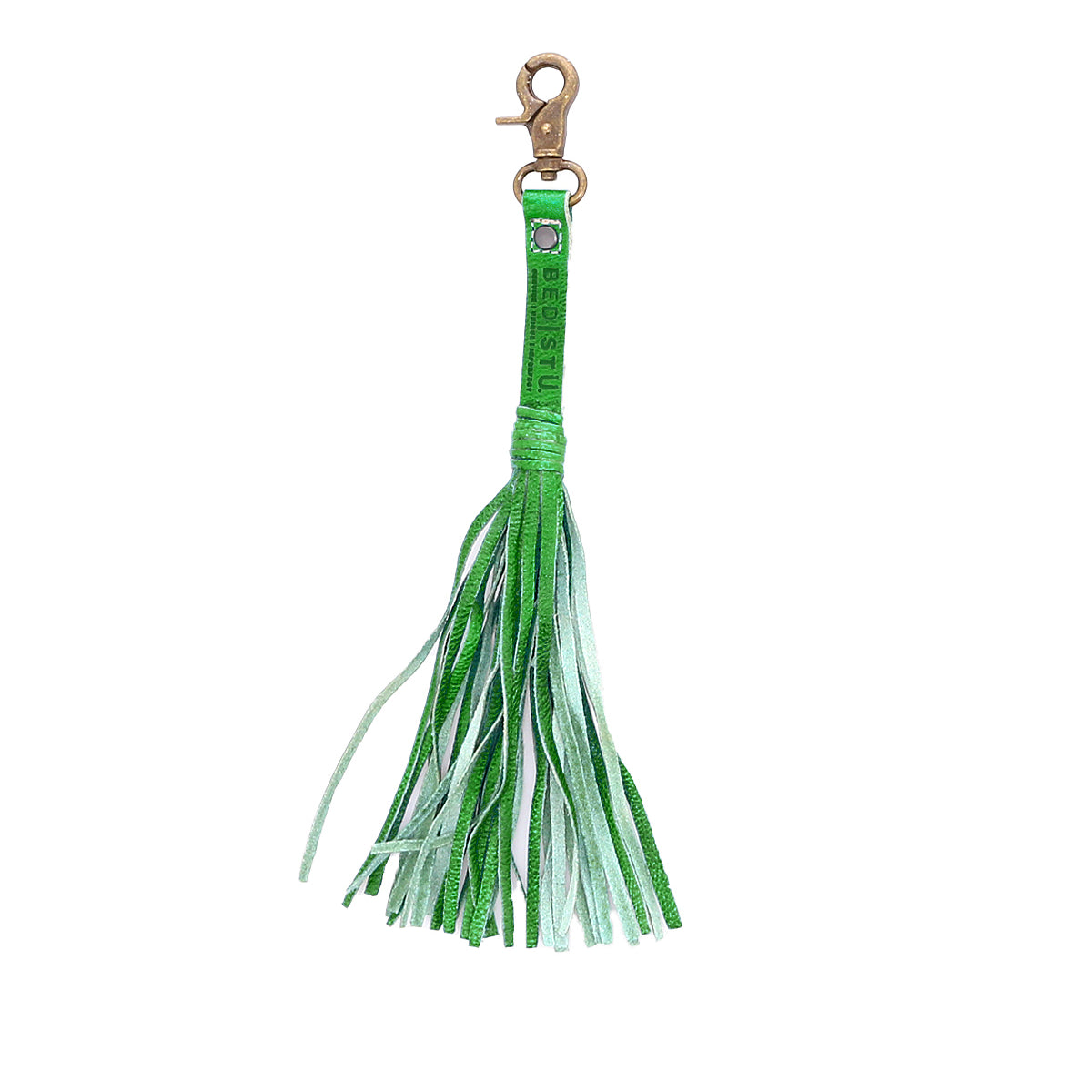 The Tassel Clip by Bed Stu is a green keychain made from premium leather, featuring a metal clip on top and fringed strands hanging down.