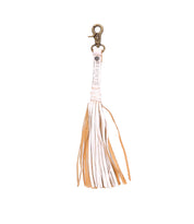 A white leather Tassel Clip keychain with tan tassels, perfect for adding a touch of personal expression to your accessories.