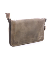 The Bed Stu Templeton II is a rectangular pouch made from brown vegetable-tanned leather, featuring visible stitching, a zippered closure, and a small embossed logo on the lower right corner.