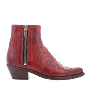 The Bed Stu Tentativa is a red leather ankle boot featuring artisan detail, decorative stitching, a side zipper, and a low stacked heel, displayed in profile on a white background.