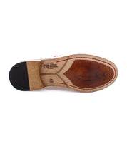 The sole of this Time penny loafer by Bed Stu showcases Italian text detailing its craftsmanship and origin. Handcrafted in Italy, the black heel is slightly raised, while the rest of the sole shows light wear and distinct stitching, making it a versatile pair for any occasion.