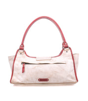 A cream-colored shoulder bag called "Unbending" by Bed Stu, featuring a structured silhouette, red handles and trim, a front zipper pocket, and the brand name on a small tag.