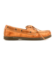 The Uncle Floyd by Bed Stu is a tan leather boat shoe featuring moccasin-style stitching, hand-finished laces around the top, and a flat rubber sole, shown in a side profile for classic nautical style.