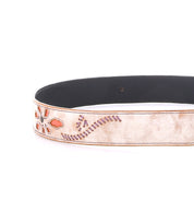 A close-up of the Bed Stu Upswing II, a handcrafted leather belt featuring orange and purple floral and swirl embroidery on a light beige background.