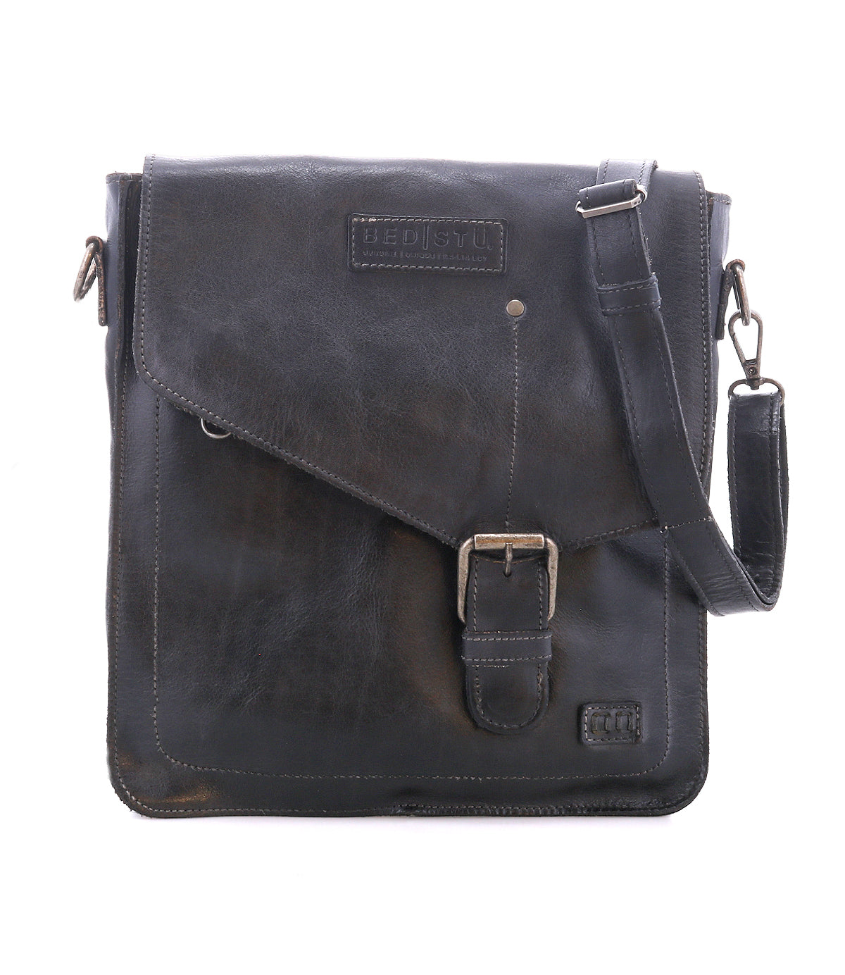 The Bed Stu Venice Beach is a black full-grain leather messenger bag featuring an adjustable shoulder strap, front flap with buckle detail, and Bed Stu branding.