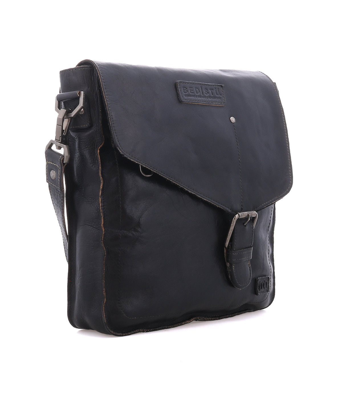 The Bed|Stü Venice Beach is a black full-grain leather messenger crossbody bag with a flap closure, buckle accent, and adjustable shoulder strap.