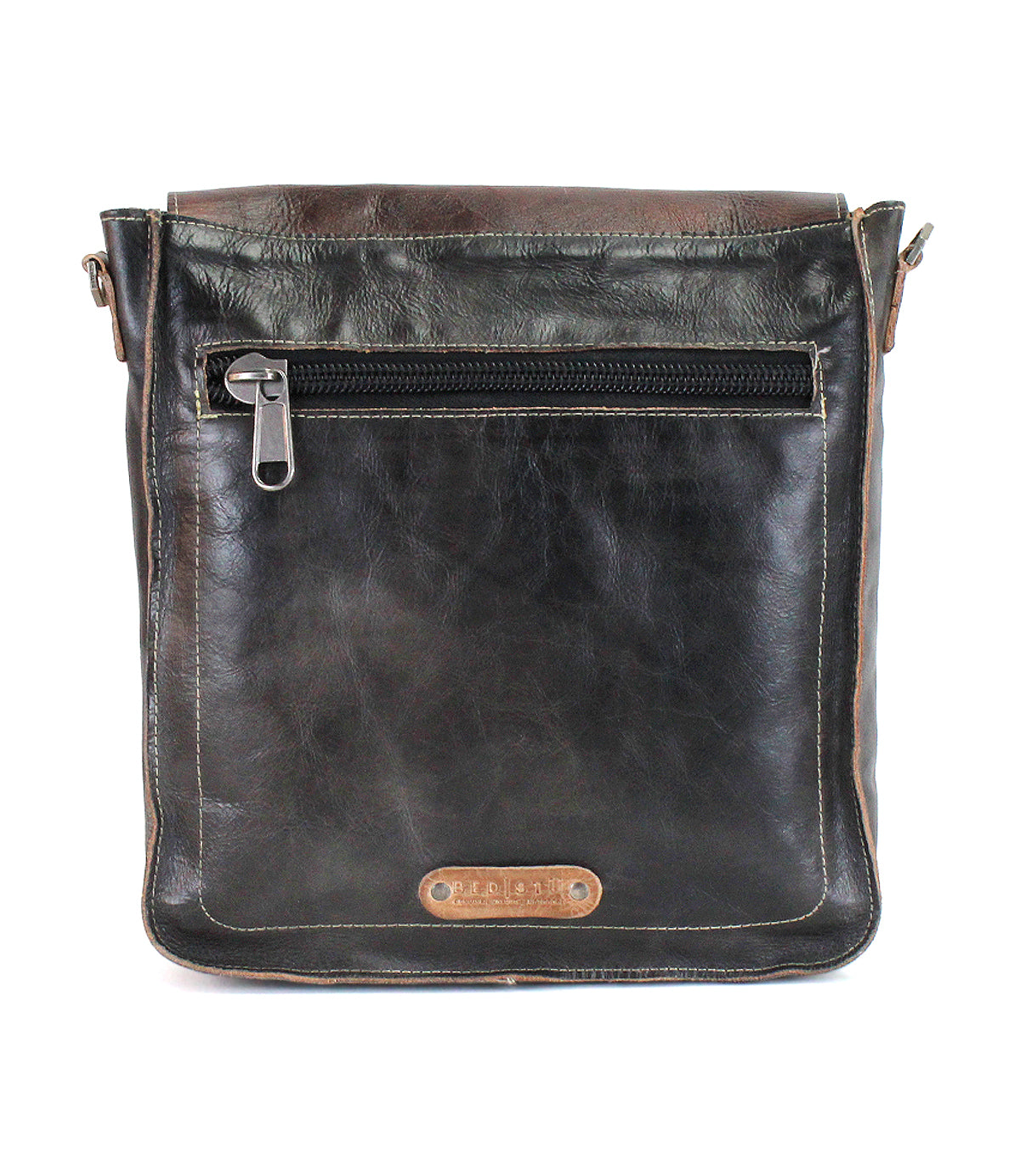 Introducing the Venice Beach by Bed|Stü—a black full-grain leather crossbody bag with brown accents, featuring a front zippered pocket and finished with a small rectangular leather patch stamped with text near the bottom.