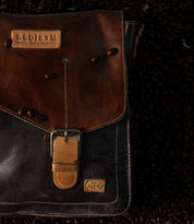 Bed|Stü Venice Beach two-toned brown full-grain leather messenger bag with an adjustable crossbody strap, a buckle closure, and branded leather patches.
