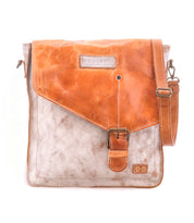 The Venice Beach by Bed Stu is a two-tone crossbody bag made of full-grain leather, featuring a tan flap, buckle closure, and an adjustable shoulder strap.