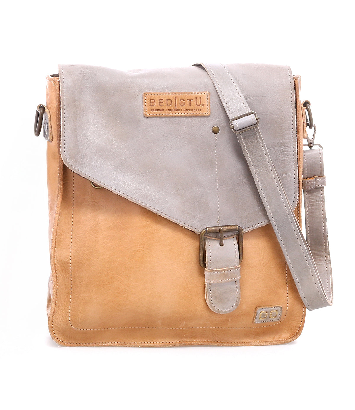 The Bed Stu Venice Beach is a vintage-inspired, two-tone handmade leather crossbody bag featuring a flap closure, adjustable strap, metal buckle, and a Bed Stu logo patch on the front.