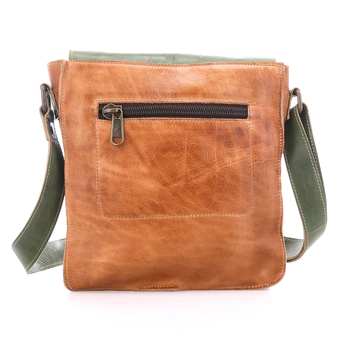 The Bed Stu Venice Beach is a handmade brown leather crossbody bag with a front zip pocket, an adjustable green strap, and a subtle boho-inspired design, displayed against a white background.