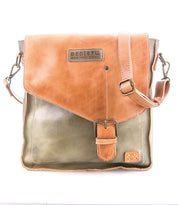 The Bed Stu Venice Beach is a two-tone full-grain leather crossbody bag with a tan flap, buckle closure, adjustable strap, and Bed Stu branding on the front.