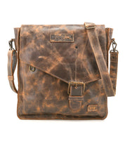 The Bed Stu Venice Beach is a vintage-inspired worn brown leather shoulder bag with a flap, buckle closure, adjustable strap, and embossed branding on the front.
