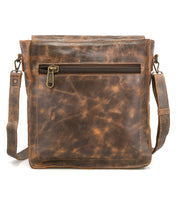 The Bed Stu Venice Beach is a handmade brown leather crossbody bag with a front zipper pocket and adjustable shoulder strap, shown against a white background.