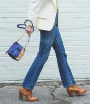 A woman in Ventura jeans and a Bed Stu leather blazer walking down the street.
