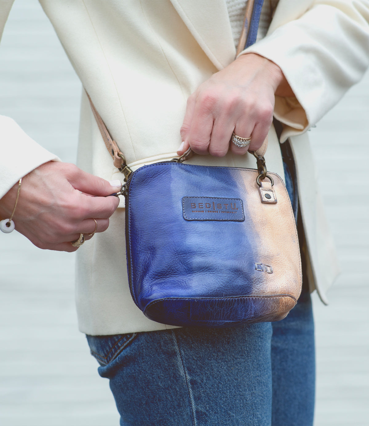 A woman holding a blue and white leather Ventura purse by Bed Stu.