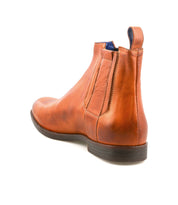 The Bed Stu Verrocchio is a men’s brown ankle boot made from genuine leather, featuring a side zipper and elastic panel for easy slip-on wear, shown from the back on a white background.