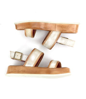 The Bed Stu Vice sandals feature platform tan soles and metallic gold adjustable ankle straps with buckles, displayed side by side on a white background.