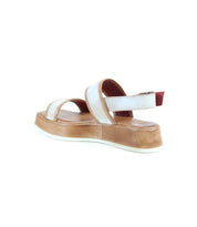 The Bed Stu Vice is a platform sandal featuring a thick tan sole, white straps, an adjustable ankle strap, and a red accent on the heel strap, shown from a rear side angle.