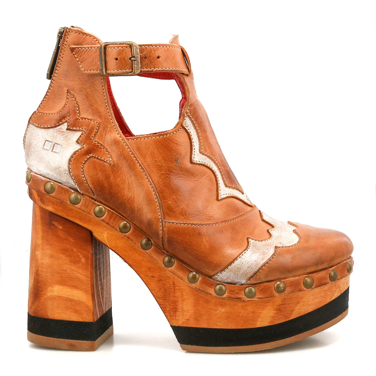The Viretta by Bed Stu is a chunky brown leather platform shoe featuring a handcrafted wooden sole, vintage-inspired design, metallic silver details, an ankle strap with buckle, and brass studs along the edge.