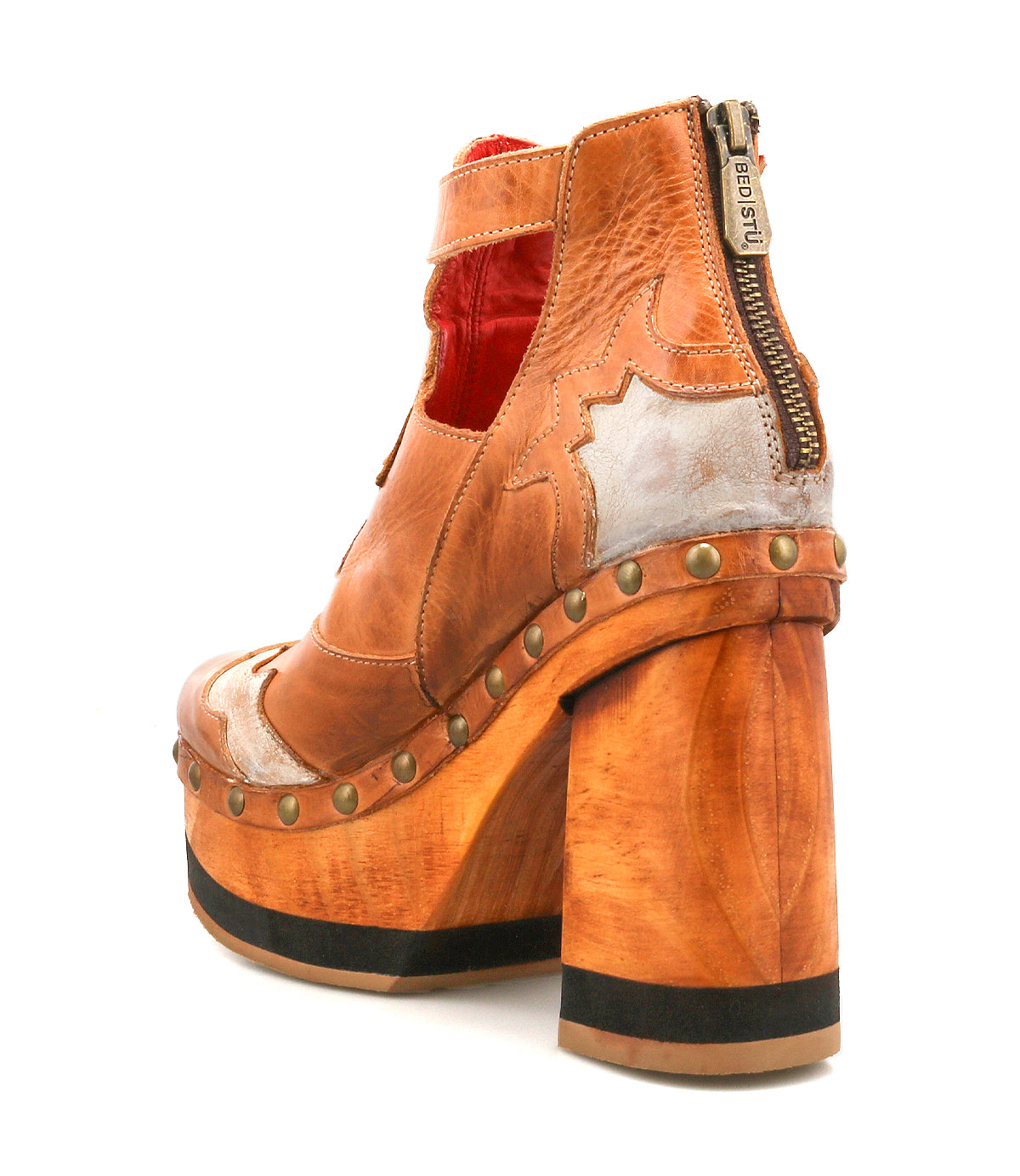 The Bed Stu Viretta is a brown leather high-heeled shoe with a handcrafted wooden platform, vintage design, metallic accents, side zipper, and decorative brass studs along the sole.