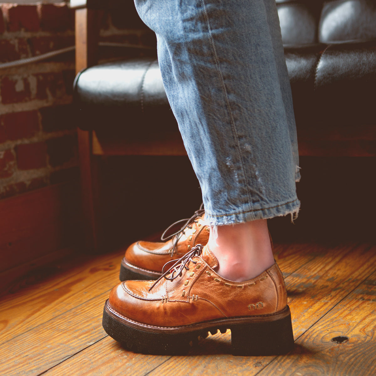 A Bed Stu Yazar wearing a pair of leather shoes on a wooden floor.