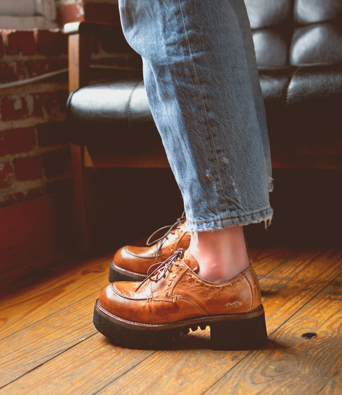 A Bed Stu Yazar wearing a pair of leather shoes on a wooden floor.