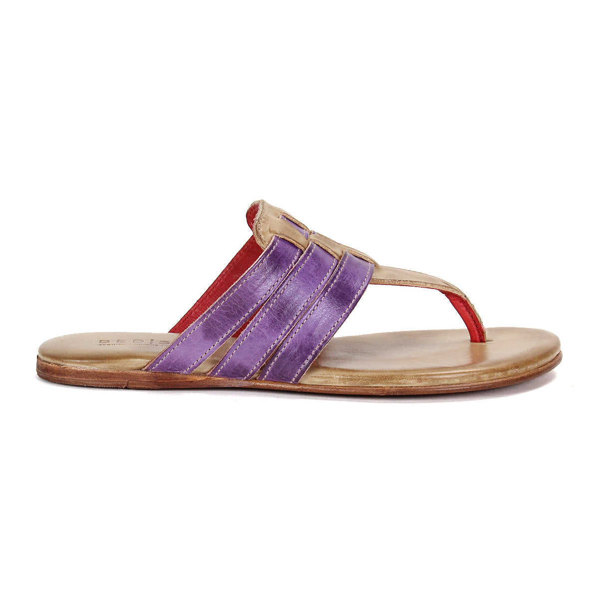 The Bed Stu Yoli sandal features a tan sole, cushioned insole for comfort, three purple straps, beige trim, and a red leather thong. Shown in side view, this flat style highlights a unique and stylish design.