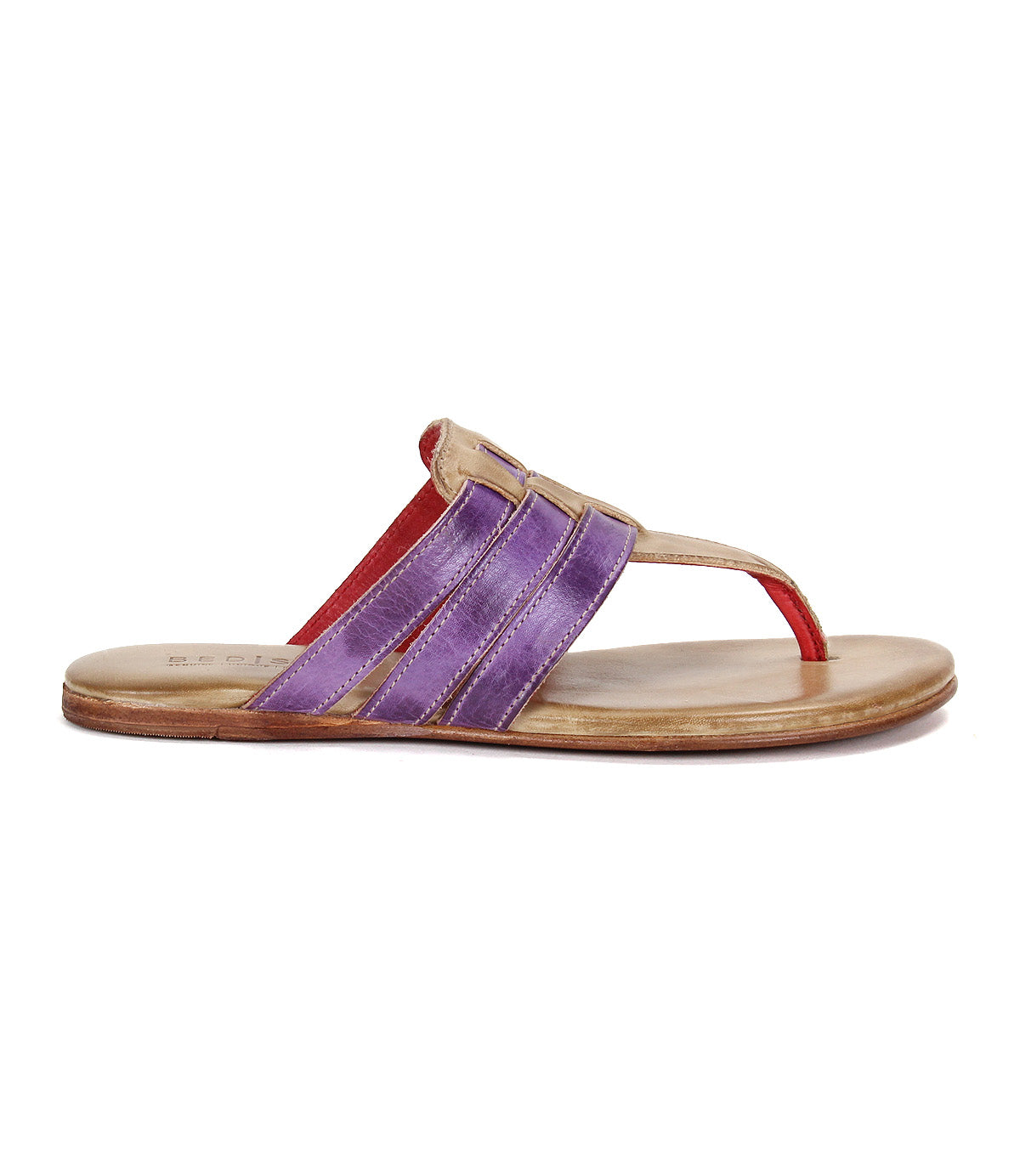 The Bed Stu Yoli sandal features a tan sole, cushioned insole for comfort, three purple straps, beige trim, and a red leather thong. Shown in side view, this flat style highlights a unique and stylish design.
