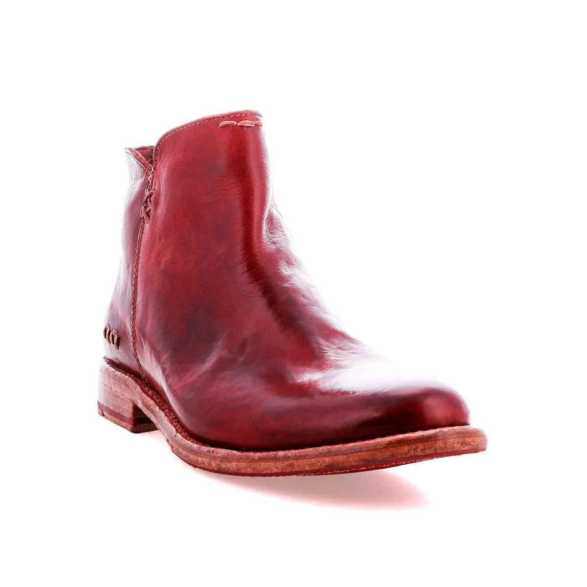 The Bed Stu Yurisa is a red leather ankle boot with a low wooden heel and red leather lining, designed for everyday wear, shown against a white background.