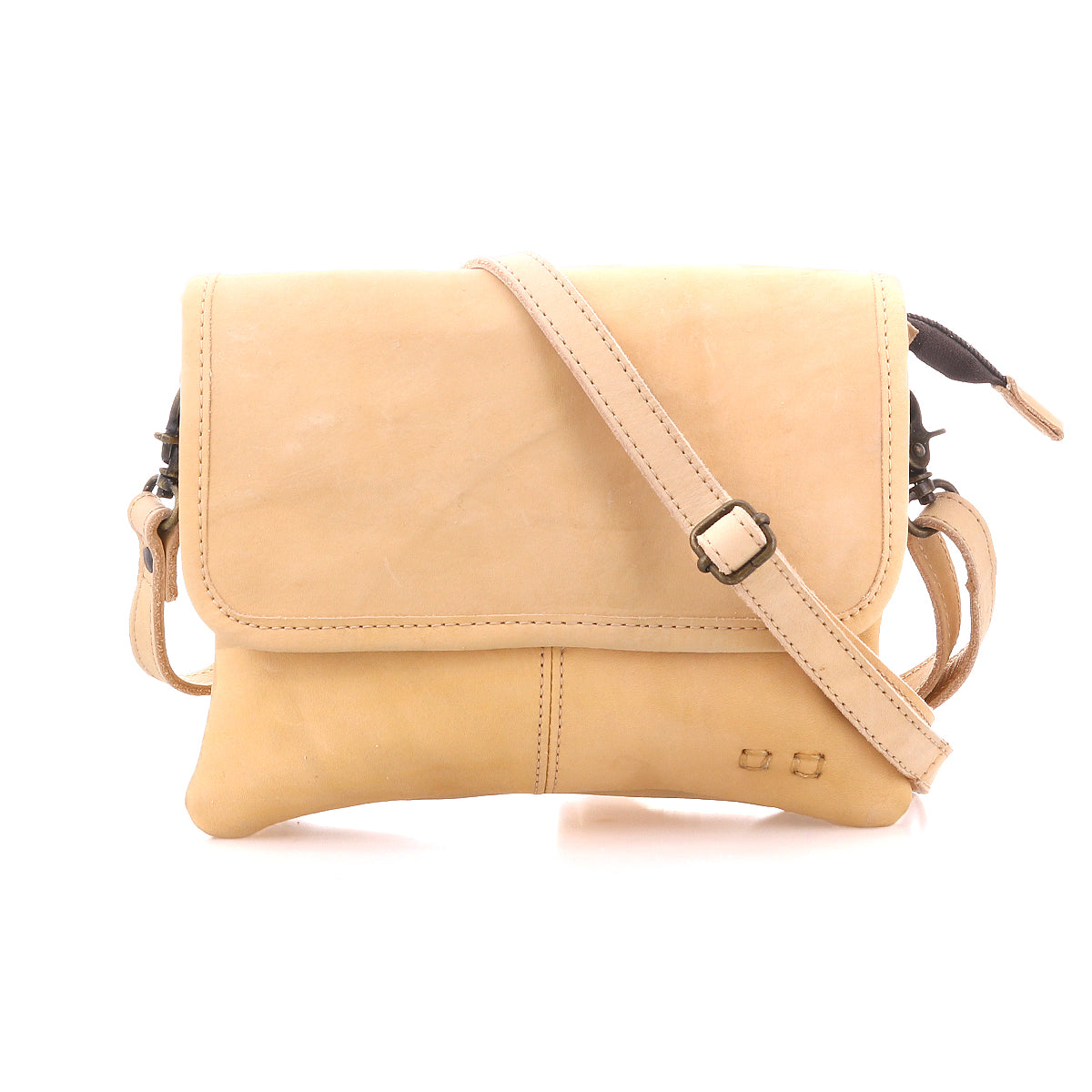 The Bed Stu Ziggy is a tan leather crossbody bag with a front flap, adjustable strap, and minimal stitching for hands-free convenience, shown against a white background.