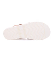 White rubber sole of a Bed Stu slide sandal named Abraham Light, with a wavy tread pattern and brand logo embossed in the center, against a white background.