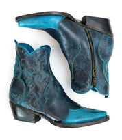 The Ace boots by Bed Stu are a pair of blue and black leather cowboy boots featuring intricate stitching, a side zipper, and durable stacked leather, embodying a modern western style.