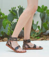 A woman wearing a pair of Bed Stu Afrodita sandals with a cactus in the background.