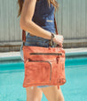 A woman wearing denim shorts and a red Bed Stu crossbody bag.