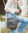 A woman carrying a Bed Stu Ainhoa crossbody handbag with an adjustable strap.