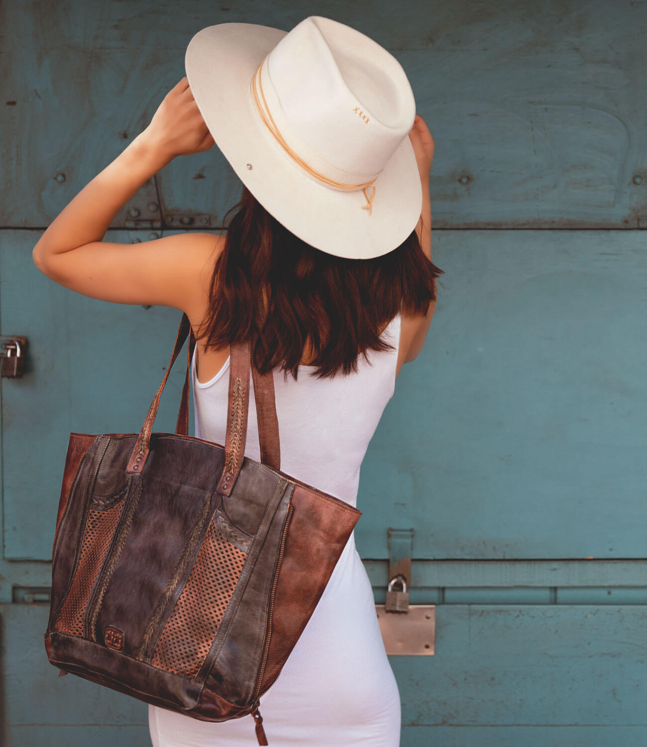 A woman wearing hat holding an Amelie bag by Bed Stu.