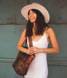A woman wearing a white dress with Amelie bag by Bed Stu.