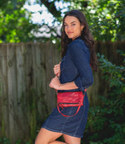 A woman in a denim dress posing with a Bed Stu Amina crossbody bag.
