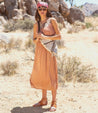 A woman in a tan "Andie" dress standing in the desert. (Brand: Bed Stu)