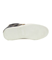 Here's a bottom view of the Andromeda, a black high-top sneaker from Bed Stu, featuring a white rubber sole. The sole displays horizontal grooves and shows signs of wear in certain areas, particularly towards the middle, accentuating its street-smart design.