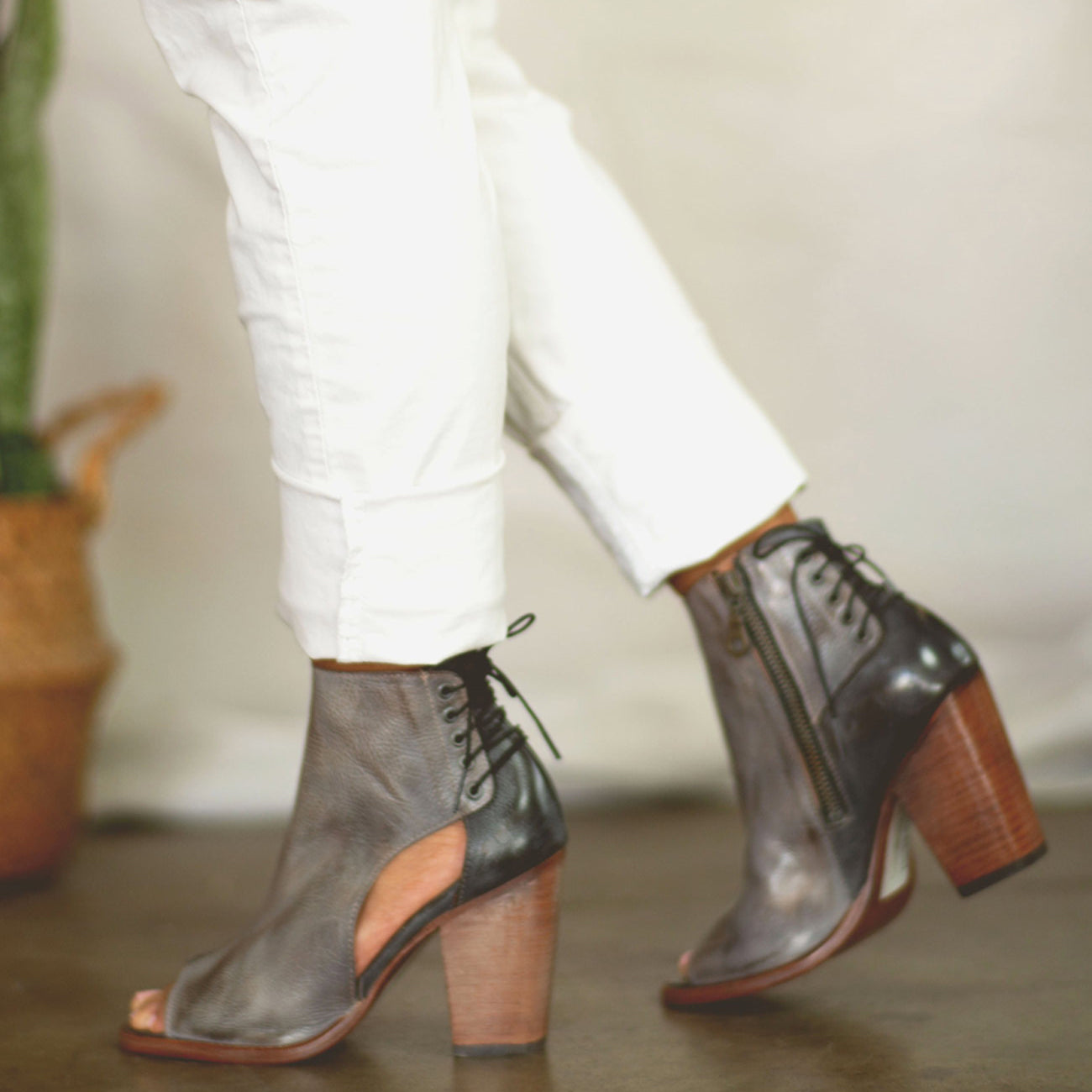 A woman wearing white pants and grey Bed Stu Angelique ankle boots.